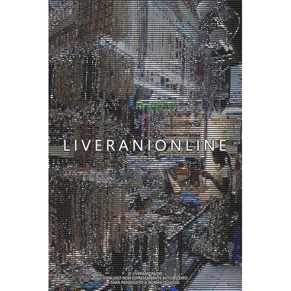 (111223) YANGON, Dec. 23, 2011 A tourist chooses goods at a shop in Yangon, Myanmar, Dec. 22, 2011. (/Song Zhenping) (cl) - Xinhua/Photoshot - ag. aldo liverani sas italy only LA VITA NELLA CITTADINA DI YANGON IN BIRMANIA