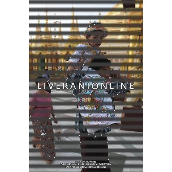(111223) YANGON, Dec. 23, 2011 People walk beside the famed Shwe Dagon Pagoda in Yangon, Myanmar, Dec. 22, 2011. (/Song Zhenping) (cl) - Xinhua/Photoshot - ag. aldo liverani sas italy only LA VITA NELLA CITTADINA DI YANGON IN BIRMANIA