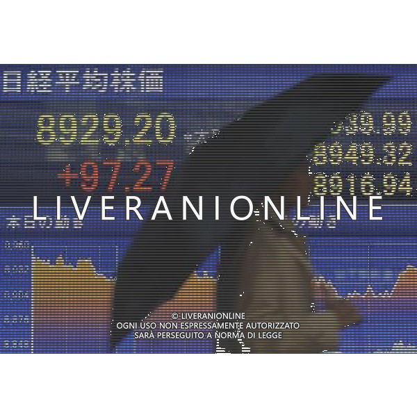 (120206) TOKYO, Feb. 6, 2012 () A pedestrian walks past a screen displaying stock information in Tokyo, capital of Japan, on Feb. 6, 2012. Tokyo stocks closed higher Monday on strong U.S. jobs data. The 225 issue Nikkei Stock Average gained 97.27 points, or 1.10 percent from Friday at 8,929.20, marking a fresh closing high since Oct. 31, 2011. (/Kenichiro Seki) (nxl) ©photoshot/Agenzia Aldo Liverani Sas - ITALY ONLY - Tabellone luminoso con schermo che visualizza le informazioni dell\'indice della borsa di Tokyo, capitale del Giappone, il 6 febbraio 2012.
