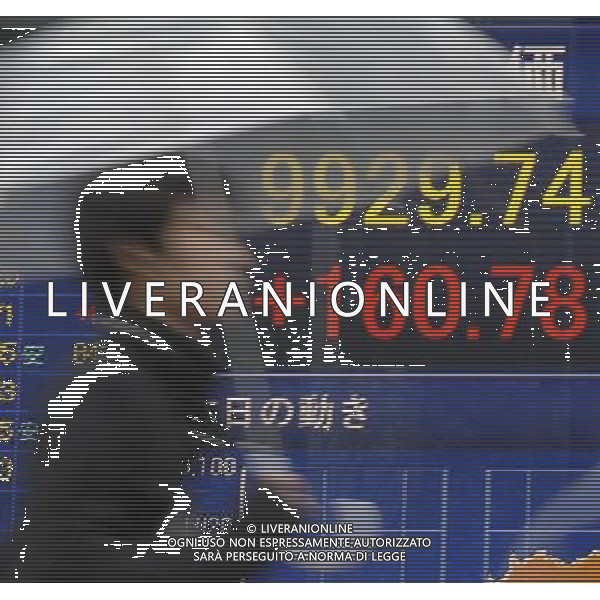 (120309) --TOKYO, March 9, 2012 () -- A pedestrian walks past a share price board in Tokyo, Japan, on March 9, 2012. Nikkei ended on Friday at its highest level since August and briefly topped 10,000 yen for the first time in seven months as Tokyo stocks surged in heavy trading as market was encouraged on eased concern over the Greek debt crisis. The 225-issue Nikkei Stock Average gained 160.78 points, or 1.65 percent, from Thursday to end at 9,929.74. (/Kenichiro Seki) (cd) ©PHOTOSHOT/Agenzia Aldo Liverani Sas - ITALY ONLY - Giappone: Tabellone luminoso con schermo che visualizza le informazioni dell\'indice della borsa di Tokyo