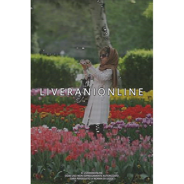 (120412) -- TEHRAN, April 12, 2012 () -- A woman takes photos of flowers at a park in Tehran, Iran, on April 12, 2012. Spring flowers blossom here as the temperature keeps rising recently. (/Ahmad Halabisaz) ©photoshot/AGENZIA ALDO LIVERANI SAS - ITALY ONLY - La gente cammina in un parco di Teheran, ricoperto da fiori di primavera dopo le alte temperature in Iran, 12 aprile 2012.