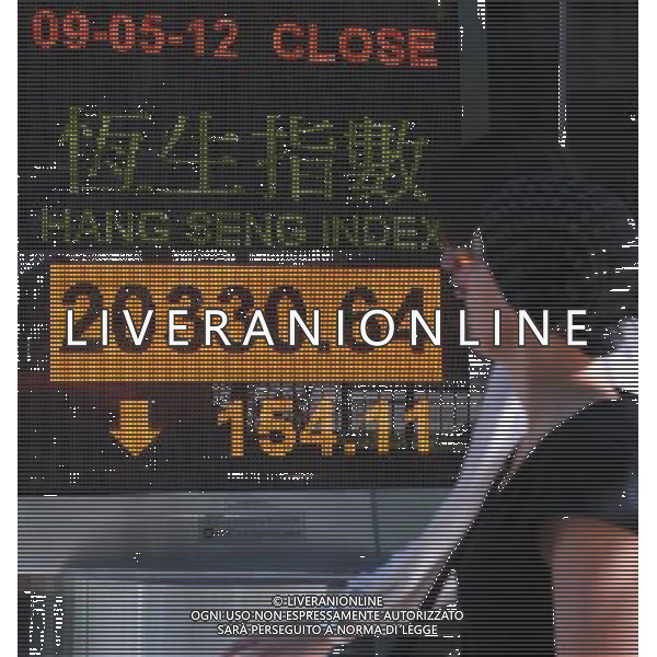(120509) -- HONG KONG, May 9, 2012 () -- Two pedestrians walk past a screenboard showing the Hang Seng index in Hong Kong, south China, May 9, 2012. The benchmark Hang Seng index closed down 154.11 points to end at 20,330.64 points, after trading between 20,257.61 and 20,371.66. (/Wong Pun Keung) (mcg) AG ALDO LIVERANI S A S ONLY ITALY