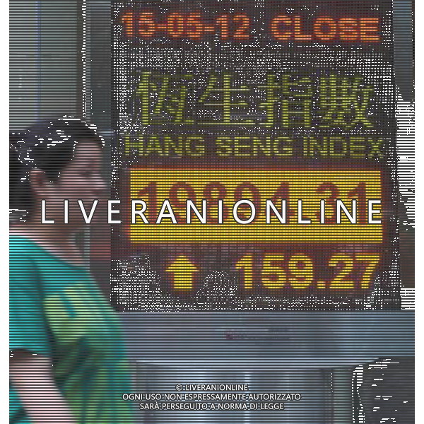 (120515) -- HONG KONG, May 15, 2012 () -- A pedestrian walks past a screenboard showing the Hang Seng index in Hong Kong, south China, May 15, 2012. The benchmark Hang Seng index rose 159.27 points, or 0.81 percent, to close at 19,894.31 on Tuesday. (/Wong Pun Keung)(mcg) /ALDO LIVERANI SAS-ITALY ONLY - EDITORIAL USE ONLY