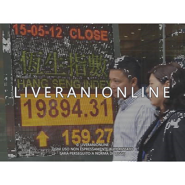 (120515) -- HONG KONG, May 15, 2012 () -- Two pedestrians walk past a screenboard showing the Hang Seng index in Hong Kong, south China, May 15, 2012. The benchmark Hang Seng index rose 159.27 points, or 0.81 percent, to close at 19,894.31 on Tuesday. (/Wong Pun Keung)(mcg) /ALDO LIVERANI SAS-ITALY ONLY - EDITORIAL USE ONLY
