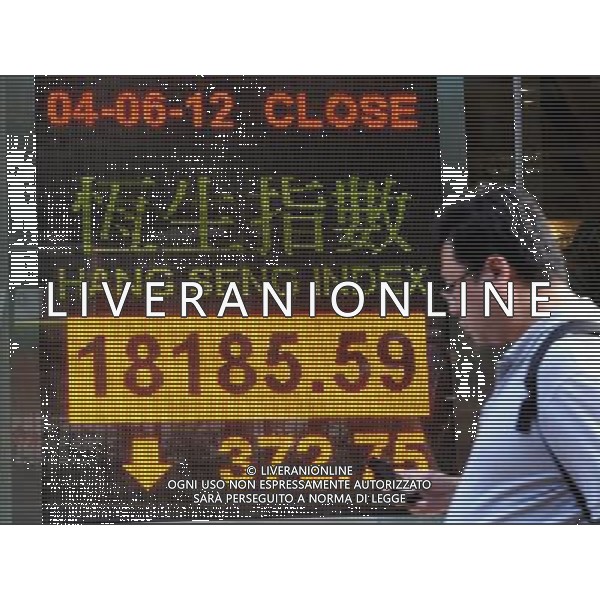 (120604) -- HONG KONG, June 4, 2012 () -- A citizen walks past an electric panel showing the Hang Seng Index in Hong Kong, south China, June 4, 2012. Hong Kong stocks fell more than 2 percent Monday to close at 18,185.59 points to reach their lowest level of 2012 so far amid rising concerns over the eurozone debt crisis. (/Wong Pun Keung) (lfj) ©PHOTOSHOT/AGENZIA ALDO LIVERANI SAS - ITALY ONLY - Tabellone elettronico che mostra l\'indice della borsa
