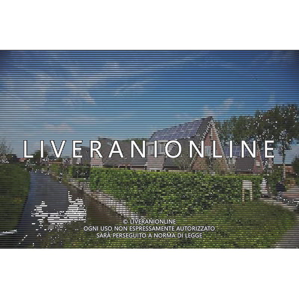 (120606) -- BEIJING, June 6, 2012 () -- Photo taken on May 11, 2012 shows houses equipped with solar panels in the City of the Sun community in Heerhugowaard, the Netherlands. City of the Sun, located in Heerhugowaard, north of Amsterdam, capital of the Netherlands, claimed to be the world\'s first and largest carbon-neutral community. The pioneering sustainable housing project has been nominated for the European Urban Planning Award as well as for the Community Sustainability Award from the International City/County Management Association (ICMA) in the United States. City of the Sun, containing some 4,000 residents in 1,500 houses, is entirely energy self-sufficient, creating as much energy as it consumes. All of the dwellings are eco-friendly, featuring solar panels, high-efficiency insulation and heat pumps. Wind turbines situated in the vicinity of the community supply some 7MW of energy, whilst the 50,000 sq meters of solar panels deliver approximately 2.45MW. Besides the sustainable energy sources, the community also uses natural water filtration systems and all homes have water retrieval tanks outside to make use of rainwater. The project contains some 4,000 residents in 1,500 houses.The development has been designed by Dutch architect and urban planner, Ashok Balohtra, who first came up with the idea of a sustainable city almost 20 years ago. One of Balohtra\'s main aims was to create a community that inspired people to lead a more environmental-friendly lifestyle. The name \'City of the Sun\' is a reference to the fact that the majority of the housing is positioned so as to derive maximum yield from solar energy for photovoltaic solar panels (it is also the largest photovoltaic community worldwide). (/Yan Ting) (lr) ©photoshot/AGENZIA ALDO LIVERANI SAS - ITALY ONLY - Pannelli solari fotovoltaici sui tetti delle abitazioni della Citta\' della comunita\' del Sole di Heerhugowaard, a nord di Amsterdam Paesi Bassi in Olanda con circa 4.000 abitanti in 1.500 case, l\'energia e\' interamente autosufficiente, generando energia per ne quanto consuma.