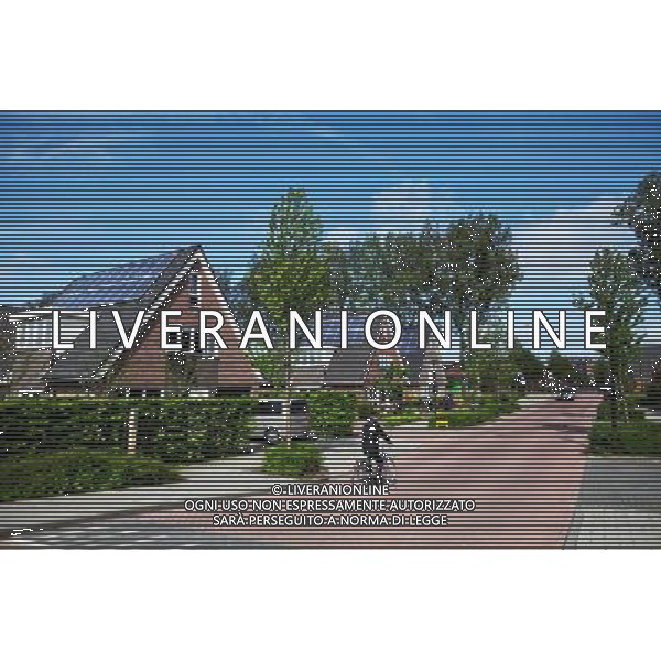 (120606) -- BEIJING, June 6, 2012 () -- Photo taken on May 11, 2012 shows houses equipped with solar panels in the City of the Sun community in Heerhugowaard, the Netherlands. City of the Sun, located in Heerhugowaard, north of Amsterdam, capital of the Netherlands, claimed to be the world\'s first and largest carbon-neutral community. The pioneering sustainable housing project has been nominated for the European Urban Planning Award as well as for the Community Sustainability Award from the International City/County Management Association (ICMA) in the United States. City of the Sun, containing some 4,000 residents in 1,500 houses, is entirely energy self-sufficient, creating as much energy as it consumes. All of the dwellings are eco-friendly, featuring solar panels, high-efficiency insulation and heat pumps. Wind turbines situated in the vicinity of the community supply some 7MW of energy, whilst the 50,000 sq meters of solar panels deliver approximately 2.45MW. Besides the sustainable energy sources, the community also uses natural water filtration systems and all homes have water retrieval tanks outside to make use of rainwater. The project contains some 4,000 residents in 1,500 houses.The development has been designed by Dutch architect and urban planner, Ashok Balohtra, who first came up with the idea of a sustainable city almost 20 years ago. One of Balohtra\'s main aims was to create a community that inspired people to lead a more environmental-friendly lifestyle. The name \'City of the Sun\' is a reference to the fact that the majority of the housing is positioned so as to derive maximum yield from solar energy for photovoltaic solar panels (it is also the largest photovoltaic community worldwide). (/Yan Ting) (lr) ©photoshot/AGENZIA ALDO LIVERANI SAS - ITALY ONLY - Pannelli solari fotovoltaici sui tetti delle abitazioni della Citta\' della comunita\' del Sole di Heerhugowaard, a nord di Amsterdam Paesi Bassi in Olanda con circa 4.000 abitanti in 1.500 case, l\'energia e\' interamente autosufficiente, generando energia per ne quanto consuma.