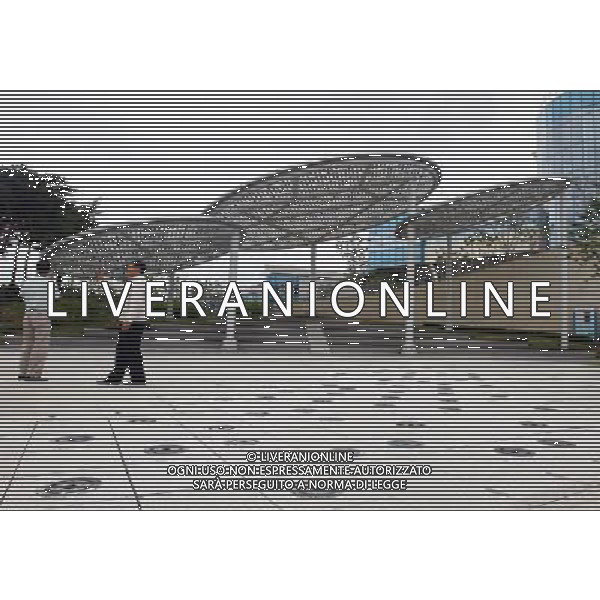 (120703) -- SEOUL, July 3, 2012 () -- People stand beside the solar equipment at the Prime Minister\'s Office building in Sejong City, 120 kms south of Seoul, South Korea, July 3, 2012. South Korea on Monday officially launched a new administrative city, a source of partisan acrimony for the past decade. Sejong City will eventually house 36 government ministries and agencies by 2014. Its current population of 120,000 is projected to jump to 500,000 by 2030. (/Yao Qilin) ©photoshot/AGENZIA ALDO LIVERANI SAS - ITALY ONLY - Progetto di urbanizzazione della citta\' di Sejong, 120 km a sud di Seoul, Corea del Sud, 3 luglio 2012 che diventera\' una cittˆ amministrativa, con 36 ministeri e agenzie governative entro il 2014. La sua popolazione attuale di 120.000 abitanti salira\' a 500.000 entro il 2030.