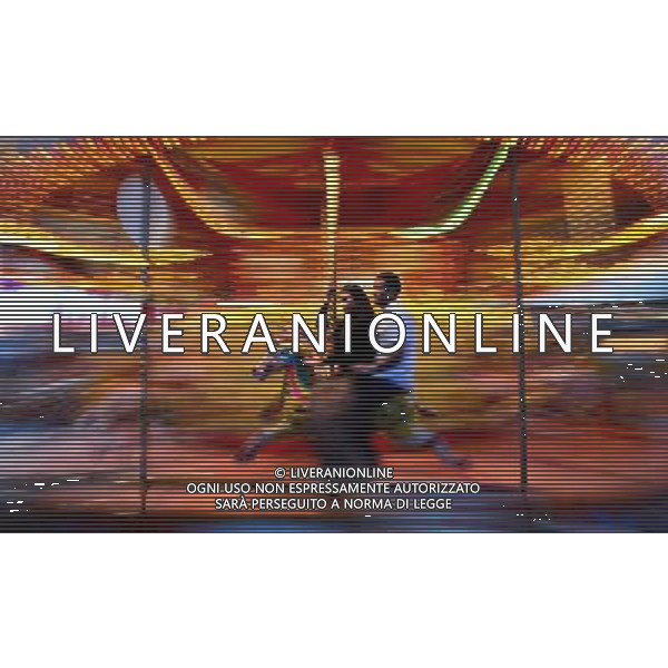 (120726) -- LONDON, July 26, 2012 () -- A couple ride on a merry-go-around near River Thames in London, Britain, on July 23, 2012. The London 2012 Olympic Games will kick off on Friday night. (/Chen Xiaowei) (nxl)