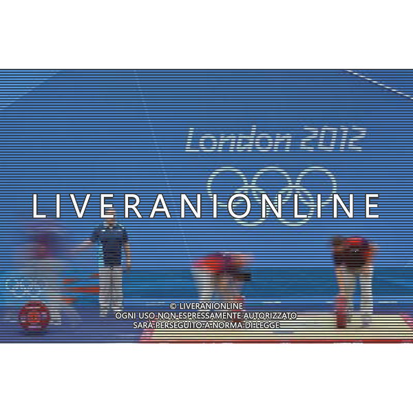 (120729) -- LONDON, July 29, 2012 () -- Volunteers adjust weight of barbells during the weightlifting competition at the London 2012 Olympic Games in London, Britain, July 29, 2012. (/Gong Lei) (zgp) /ALDO LIVERANI SAS-ITALY ONLY - EDITORIAL USE ONLY