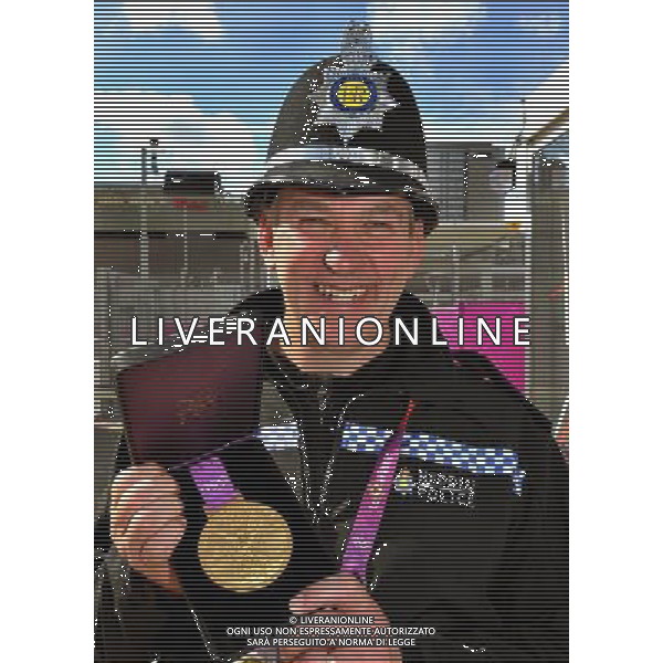 Police Officer Mark Riddick from the Gwent Police force holds the Olympic Gold Medal, during the Village Mayors trip around the Olympic Athletes village, in Stratford east London. /PHOTOSHOT/ALDO LIVERANI ITALY ONLY -