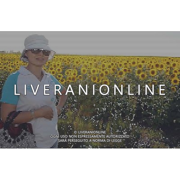 (120810) -- QAPQAL, Aug. 10, 2012 () -- A tourist poses for pictures with blooming sunflowers in Qapqal Xibe Autonomous County of northwest China\'s Xinjiang Uygur Autonomous Region, Aug. 7, 2012. Beautiful sunflowers attracted tourists from near and far. (/Sadat) (/Sadat) ©PHOTOSHOT/Agenzia Aldo Liverani Sas - ITALY ONLY - CAMPI DI GIRASOLI IN FIORE A QAPQAL, CINA 10 agosto 2012