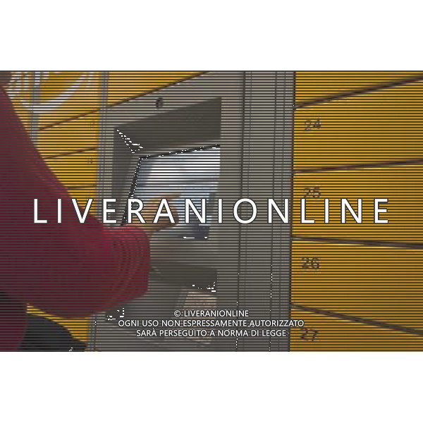 An Amazon customer picks up her package in an Amazon Locker in a supermarket New York on Tuesday, September 4, 2012. The lockers, placed in grocery and convenience stores in mostly urban areas, enable customers, who work and do not have doorman or another party, to receive their purchase in a secure location. When delivered the purchaser receives an email with a code which pops open a door in the locker. (å Richard B. Levine) photoshot/AG ALDO LIVERANI SAS - ITALY ONLY -