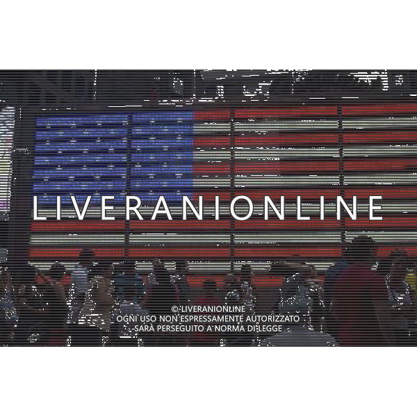 Tourists in front of an electronic American Flag which adorns the sides of the Armed Forces Recruitment booth on Military Island in Times Square, seen on Sunday, September 2, 2012. (å Frances M. Roberts) photoshot/AG ALDO LIVERANI SAS - ITALY ONLY -