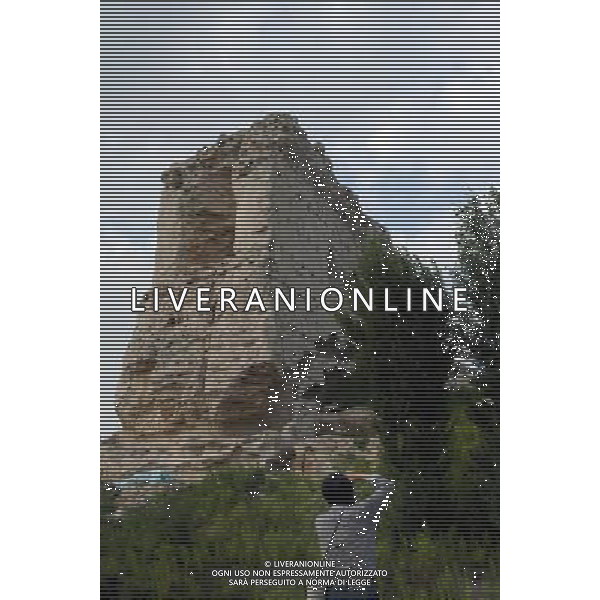 (120914) -- JINGBIAN, Sep. 14, 2012 () --A tourist takes photos of the Tongwancheng ruins in Jingbian County, northwest China\'s Shaanxi Province, Aug. 23, 2012. Tongwancheng was the capital city of the Xiongnu (Hun) 1,600 years ago. The Xiongnu was a northern nomadic ethnic group that was influential in northern China for 10 centuries in ancient times. The Tongwancheng walls are made with sand and white-powdered earth mixed with glutinous rice water. This mixture makes the earthen walls as hard as the stone walls. In 1996, the State Council designated Tongwancheng as the national key cultural relics protection unit. Now the local government is preparing to apply for world cultural heritage. (/Tao Ming) (cl) ©photoshot/Agenzia Aldo Liverani Sas - ITALY ONLY - Veduta delle rovine della citta\' di Tongwancheng in Jingbian County, provincia di Shaanxi nord-ovest della Cina che era la capitale della Xiongnu (Hun) 1600 anni fa.