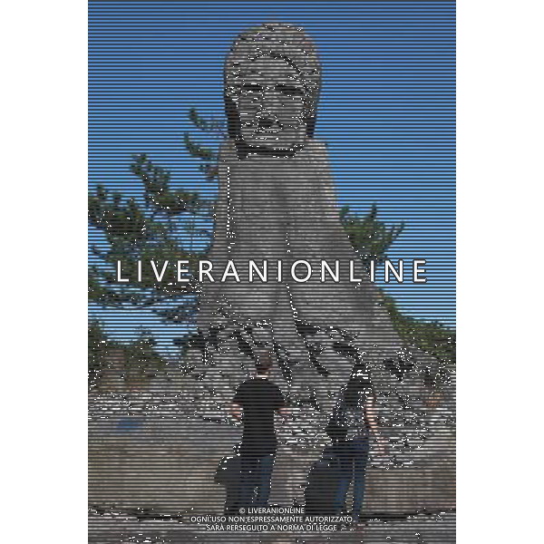 (120914) -- JEJU ISLAND, Sept. 14, 2012 () -- Tourists look at statues with expressive faces at an outdoor sculpture garden on South Korea\'s Jeju Island, Sept. 12, 2012. Mushroom-looking lava rock statues with expressive faces are a ubiquitous presence on the convoluted alleys on Jeju Island, a semi-tropical resort island off the southern tip of South Korea. (/Park Jin hee) ©photoshot/AGENZIA ALDO LIVERANI SAS - ITALY ONLY - Le statue di pietra lavica con volti espressivi su Jeju Island, un\'isola semi tropicale al largo della punta meridionale del Sud Corea 12 settembre, 201