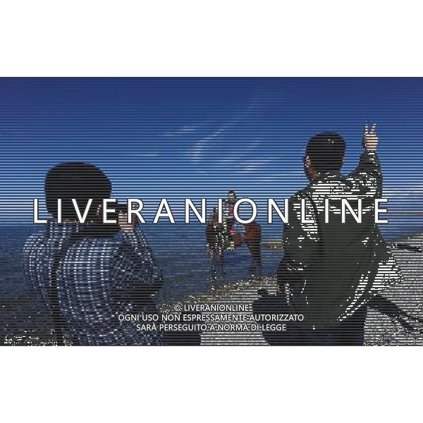 (121004) -- QINGHAI, Oct. 4, 2012 () -- Tourists pose for photos at the Qinghai Lake in northwest China\'s Qinghai Province, Oct. 3, 2012. The Qinghai Lake, as the largest inland salt-water lake in China renowned for the ecological and natural reserve, attracted tourists from home and abroad during the National Day holiday. (/Zhang Hongxiang) (mp) AG ALDO LIVERANI S A S ONLY ITALY