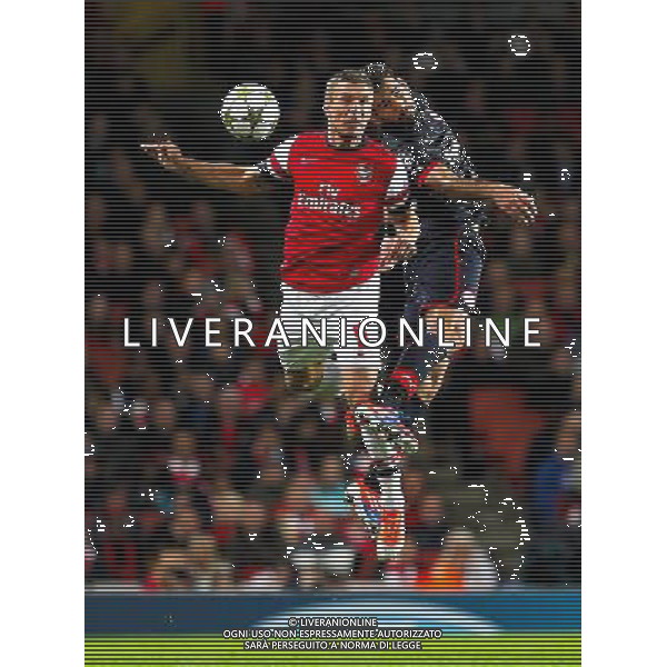 (121004) -- LONDON, Oct. 4, 2012 () -- Lukas Podolski (L) of Arsenal vies for the ball during the UEFA Champions League Group B match between Arsenal FC and Olympiacos FC at the Emirates Stadium in London, Britain on Oct. 3, 2012. Arsenal won 3-1. (/Wang Lili) ©PHOTOSHOT/AGENZIA ALDO LIVERANI SAS - ITALY ONLY - EDITORIAL USE ONLY