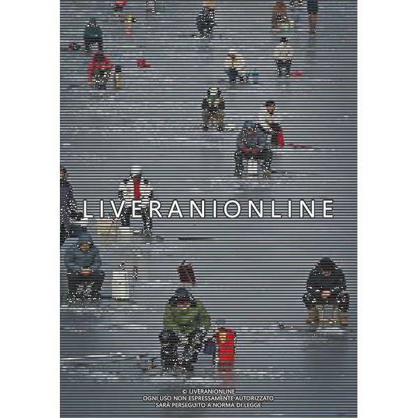 (121221) -- TIANJIN, Dec. 21, 2012 () -- Citizens do ice-fishing on a frozen river in Tianjin, north China, Dec. 21, 2012. People chose to relax in the Haihe River despite a low temperature these days. (/Yue Yuewei) (zz) ©photoshot/AGENZIA ALDO LIVERANI SAS - ITALY ONLY - La gente ha scelto di rilassarsi nel fiume Haihe, nonostante la bassa temperatura di questi giorni a Tianjin, nel nord della Cina, 21 dicembre, 2012.