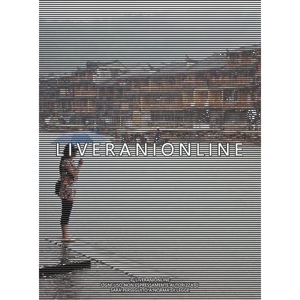 (130429) -- FENGHUANG, April 29, 2013 () -- A woman enjoys the scenery by the side of Tuojiang River near the ancient town of Fenghuang in Fenghuang County of Xiangxi Tu and Miao Autonomous Prefecture, central China\'s Hunan Province, April 29, 2013. Fenghuang witnessed rainfall on Monday, the first day of the three-day Labor Day holiday. (/Zhao Zhongzhi) (wjq) FENGHUANG, Aprile 29, 2013 - Scenario del fiume Tuojiang vicino all\'antica citta\' di Fenghuang nella regione Fenghuang di Xiangxi Tu nella Cina centrale. (/Zhao Zhongzhi) (wjq) ©Photoshot/Ag. Aldo Liverani s.a.s.-Only Italy-Editorial Use Only