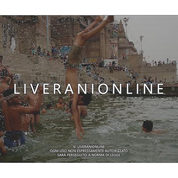 (130528) --VARANASI, May 28, 2013 () -- A man jumps into the River Ganges to beat the heat in the holy city Varanasi, India, May 28, 2013. Many parts of northern India face terrible heat wave. () ©photoshot/AGENZIA ALDO LIVERANI SAS - ITALY ONLY - Le persone si tuffano nel fiume Gange per rinfrescarsi e combattere il grande caldo nella citta\' santa di Varanasi, in India, 28 maggio 2013.