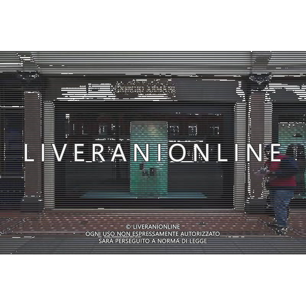 Man selling The Big Issue outside Giorgio Armani Shop, Knightsbridge, London, England AG ALDO LIVERANI SAS ONLY ITALY