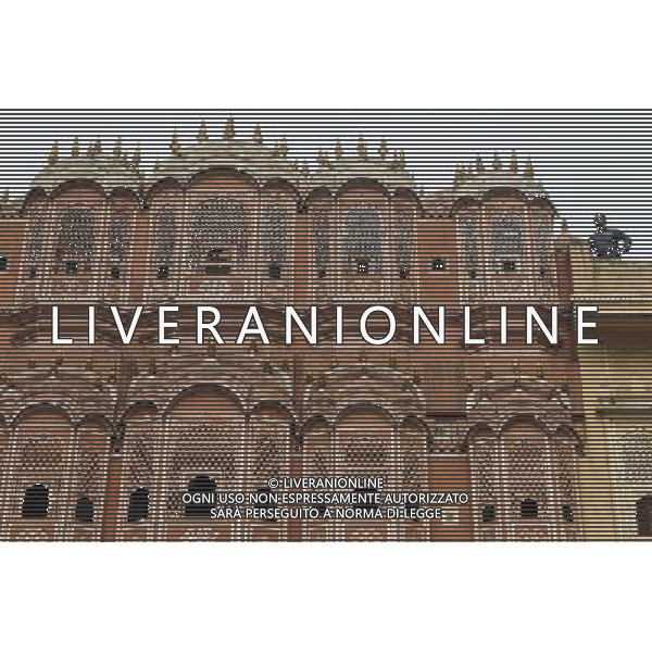 (130613) -- JAIPUR, June 13, 2013 () -- People visit the Hawa Mahal in Jaipur, capital of Rajasthan, India, June 13, 2013. The Hawa Mahal, also known as Palace of Winds, is a landmark palace in Jaipur. It was built in 1799 from red and pink sandstone with the intention to allow royal ladies to observe life outside the palace. The lattice on the wall was designed to prevent them from being seen, since they followed strict face cover rules. The Hawa Mahal\'s five-storey exterior has 953 small windows, which together with the lattice provides cool air during the high temperatures in summers. (/Zheng Huansong) ©Photoshot/AGENZIA ALDO LIVERANI SAS-ITALY ONLY - EDITORIAL USE ONLY