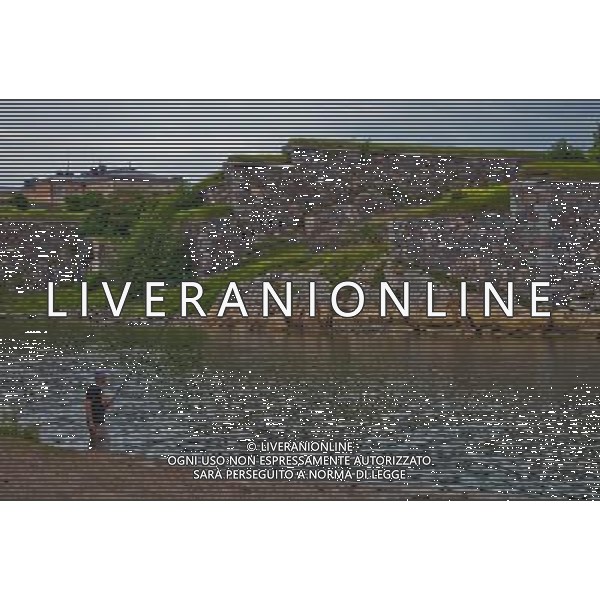 (130628) -- HELSINKI, June 28, 2013() -- A man fishes outside the island fortress of Suomenlinna in Helsinki, capital of Finland, on June 24, 2013. Fortress of Suomenlinna is a unique historical monument and one of the largest maritime fortresses in the world. Its construction began in 1700s when Finland was part of the Kingdom of Sweden. As an example of European military architecture of its time, Suomenlinna was included in UNESCO\'s World Heritage List in 1991. (/Yan Ting) AG ALDO LIVERANI SAS ONLY ITALY