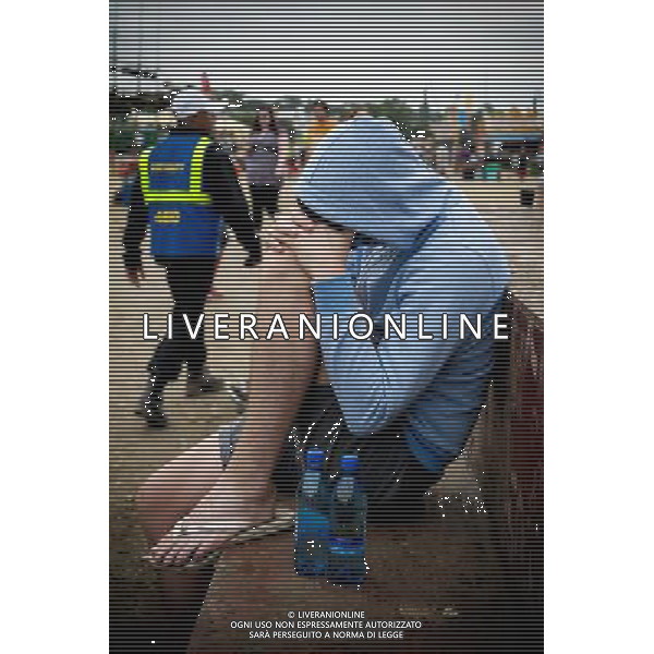Atmosphere at Glastonbury Festival on 30/06/2013 at Worthy Farm, Glastonbury. Man in hoddie with head down on knees in the morning. ©photoshot/AGENZIA ALDO LIVERANI SAS - ITALY ONLY - EDITORIAL USE ONLY