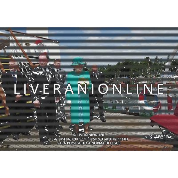 Queen Elizabeth II accompanied by Bill Bewley, Chairman of Windermere Lake Cruises, stands aboard the Teal cruise boat at Bowness on Windermere pier, Cumbria. The Queen said today that she is hoping the royal baby is born soon - because she is about to go on holiday. She made the comment in reply to a question from a 10-year-old schoolgirl while on a series of engagements in the Lake District. ©photoshot/AGENZIA ALDO LIVERANI SAS - ITALY ONLY - REALI INGLESI: La Regina Elisabetta II d\'inghilterra in visita al lago di Windermere, Cumbria
