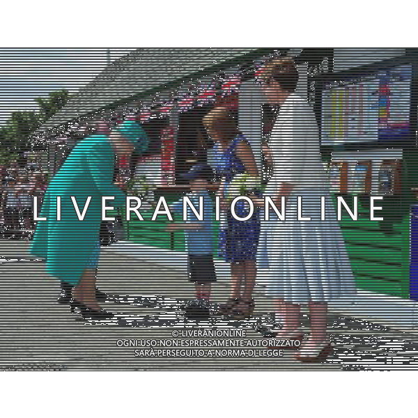Queen Elizabeth II is presented with a posy of flowers by Daniel Dixon, aged six, from St Mary\'s Primary School Windermere, as she arrives at Bowness on Windermere pier, Cumbria. The Queen said today that she is hoping the royal baby is born soon - because she is about to go on holiday. She made the comment in reply to a question from a 10-year-old schoolgirl while on a series of engagements in the Lake District. ©photoshot/AGENZIA ALDO LIVERANI SAS - ITALY ONLY - REALI INGLESI: La Regina Elisabetta II d\'inghilterra in visita al lago di Windermere, Cumbria