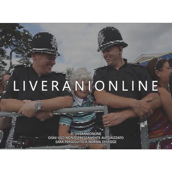 BUILTH WELLS, WALES - JULY 24: A woman stands between two police officers as she waits for the Prince Charles, Prince of Wales to arrive at the Royal Welsh Show at Royal Wales Showground on July 24, 2013 in Builth Wells, Wales. ©photohsot/AGENZIA ALDO LIVERANI SAS - ITALY ONLY - REALI INGLESI: Il Principe Carlo d\'Inghilterra e la moglie Camilla Duchessa di Cornovaglia al Royal Welsh Show Showground 24 luglio 2013 in Builth Wells, Galles. 