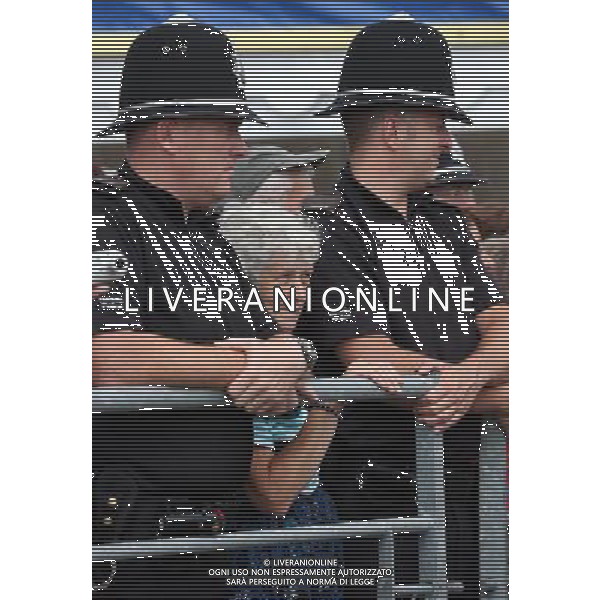 BUILTH WELLS, WALES - JULY 24: A woman stands between two police officers as she waits for the Prince Charles, Prince of Wales to arrive at the Royal Welsh Show at Royal Wales Showground on July 24, 2013 in Builth Wells, Wales. ©photohsot/AGENZIA ALDO LIVERANI SAS - ITALY ONLY - REALI INGLESI: Il Principe Carlo d\'Inghilterra e la moglie Camilla Duchessa di Cornovaglia al Royal Welsh Show Showground 24 luglio 2013 in Builth Wells, Galles. 