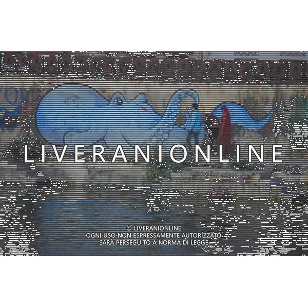 (130811) -- RAJASTHAN, Aug. 11, 2013 () -- Tourists walk by a wall with painting in Udaipur, India\'s Rajasthan, Aug. 11, 2013. Located in the south of India\'s Rajasthan, Udaipur was built by Udai Singh in 16th century along the Pichola Lake. Nowadays, many of the ancient palaces have been converted into luxury hotels. Being rich in lakes, Udaipur is often called the \'Venice of the East\'. Every year, its ancient buildings, arts and craft works attract many visitors from the world. (/Zheng Huansong) ©photoshot/AGENZIA ALDO LIVERANI SAS - ITALY ONLY - Vedute della citta indiana di Udaipur, nel Rajasthan nel sud dell\'India costruita nel 16mo secolo lungo il lago Pichola. Antichi palazzi sono stati trasformati in alberghi di lusso e\' chiamata la \'Venezia d\'Oriente\' e attira molti turisti da tutto il mondo