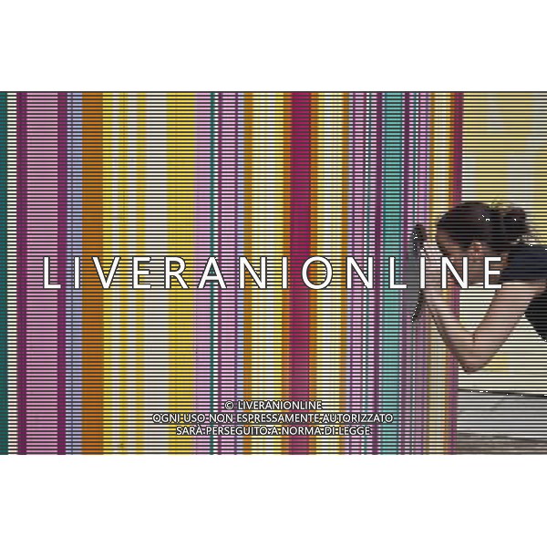 A woman looks through the window of a beach hut, erected for the festival of Britain, The Southbank, London, England ©PHOTOSHOT/AGENZIA ALDO LIVERANI SAS - ITALY ONLY - EDITORIAL USE ONLY