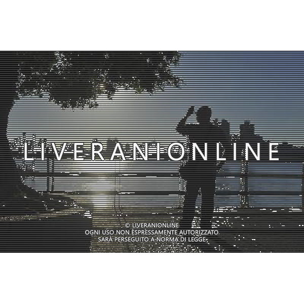 (130827) -- TAIPEI, Aug. 27, 2013 () -- A man takes photo of the sunset by the Dadaocheng Wharf in Taipei, southeast China\'s Taiwan, Aug. 27, 2013. Dadaocheng was an important trading port in the 19th century, and is now a tourist attraction and shopping area. (/Lu Peng) (mp) ©photoshot/AGENZIA ALDO LIVERANI SAS - ITALY ONLY - Vedute panoramih“che della citta\' e del molo di Dadaocheng, con un importante porto commerciale nel 19mo secolo, e\' ora un\'attrazione turistica a Taipei, sud-est della Cina, Taiwan, 27 agosto 2013.