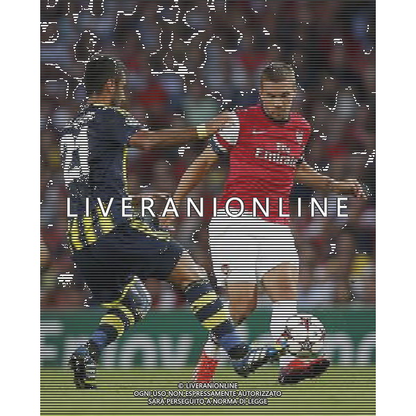 (130828) -- LONDON, Aug. 28, 2013 () -- Lukas Podolski (R) of Arsenal vies with Selcuk Sahin of Fenerbahce during the UEFA Champions League Play-off Round Second leg match between Arsenal FC and Fenerbahce SK at Emirates Stadium in London, Britain on Aug. 27, 2013. Arsenal won 2-0 in this match. Arsenal defeated Fenerbahce with a 5-0 in aggregate to reach the Champions League for the 16th consecutive year.(/Wang Lili)