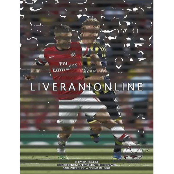 (130828) -- LONDON, Aug. 28, 2013 () -- Jack Wilshere (L) of Arsenal vies with Dirk Kuyt of Fenerbahce during the UEFA Champions League Play-off Round Second leg match between Arsenal FC and Fenerbahce SK at Emirates Stadium in London, Britain on Aug. 27, 2013. Arsenal won 2-0 in this match. Arsenal defeated Fenerbahce with a 5-0 in aggregate to reach the Champions League for the 16th consecutive year.(/Wang Lili)