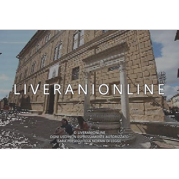 (130926) -- PIENZA (ITALY), Sept. 26, 2013 () -- Two tourists sit beside the well of dogs out side the Piccolomini Palace in Pienza, Italy, Sept. 25, 2013. It was in this Tuscan town that Renaissance town-planning concepts were first put into practice after Pope Pius II decided, in 1459, to transform the look of his birthplace. He chose the architect Bernardo Rossellino, who applied the principles of his mentor, Leon Battista Alberti. This new vision of urban space was realized in the superb square known as Piazza Pio II and the buildings around it: the Piccolomini Palace, the Borgia Palace and the cathedral with its pure Renaissance exterior and an interior in the late Gothic style of south German churches. The UNESCO Commitee inscribed the historic enter of the city of Pienza as a world heritage site in 1996. (/Du Juanjuan) (jl) ©photoshot/AGENZIA ALDO LIVERANI SAS - ITALY ONLY - EDITORIAL USE ONLY - VEDUTE DEL CENTRO STORICO DELLA CITTA\' DI PIENZA IN PROVINCIA DI SIENA IN TOSCANA iscritta dal Comitato UNESCO come sito del patrimonio mondiale nel 1996