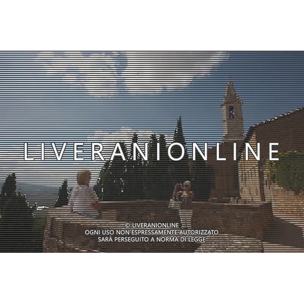 (130926) -- PIENZA (ITALY), Sept. 26, 2013 () -- Two tourists take photos beside the city wall of Pienza, Italy, Sept. 25, 2013. It was in this Tuscan town that Renaissance town-planning concepts were first put into practice after Pope Pius II decided, in 1459, to transform the look of his birthplace. He chose the architect Bernardo Rossellino, who applied the principles of his mentor, Leon Battista Alberti. This new vision of urban space was realized in the superb square known as Piazza Pio II and the buildings around it: the Piccolomini Palace, the Borgia Palace and the cathedral with its pure Renaissance exterior and an interior in the late Gothic style of south German churches. The UNESCO Commitee inscribed the historic enter of the city of Pienza as a world heritage site in 1996. (/Du Juanjuan) (jl) ©photoshot/AGENZIA ALDO LIVERANI SAS - ITALY ONLY - EDITORIAL USE ONLY - VEDUTE DEL CENTRO STORICO DELLA CITTA\' DI PIENZA IN PROVINCIA DI SIENA IN TOSCANA iscritta dal Comitato UNESCO come sito del patrimonio mondiale nel 1996