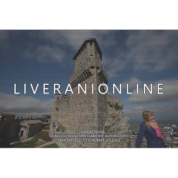 (131002) -- ROMA, Oct. 2, 2013 () -- A tourist poses for a photo in front of Guaita Tower in San Marino on Oct. 1, 2013. San Marino Historic Centre and Mount Titano covers 55 ha, including Mount Titano and the historic centre of the city which dates back to the foundation of the republic as a city-state in the 13th century. The inscribed city centre includes fortification towers, walls, gates and bastions, as well as a neo-classical basilica of the 19th century, 14th and 16th century convents, and the Palazzo Publico of the 19th century, as well as the 18th century Titano Theatre. The property represents an historical centre still inhabited and preserving all its institutional functions. The UNESCO Commitee inscribed San Marino Historic Centre and Mount Titano as a world heritage site in 2008. (/Du Juanjuan) ©photoshot/AGENZIA ALDO LIVERANI SAS - ITALY ONLY - EDITORIAL USE ONLY ©photoshot/AGENZIA ALDO LIVERANI SAS - ITALY ONLY - EDITORIAL USE ONLY ©PHOTOSHOT/AGENZIA ALDO LIVERANI SAS - ITALY ONLY - EDITORIAL USE ONLY