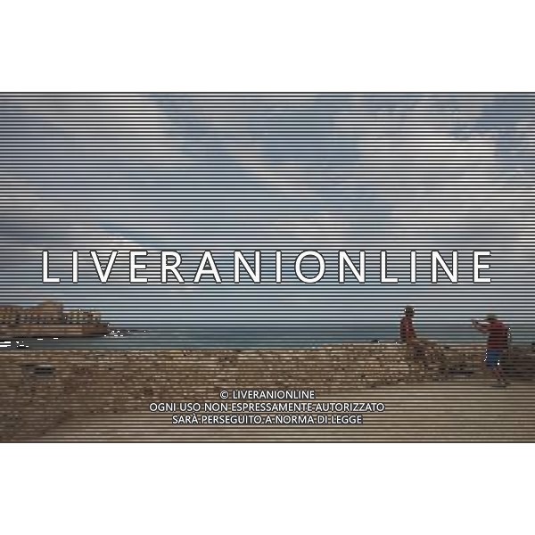 (131008) -- SYRACUSE, Oct. 8, 2013 () -- A couple take photos at the seaside in Syracuse, Italy, Oct. 7, 2013. Ancient Syracuse includes the nucleus of the city\'s foundation as Ortygia by Greeks from Corinth in the 8th century BC. The site of the city, which Cicero described as \'the greatest Greek city and the most beautiful of all\', retains vestiges such as the Temple of Athena (5th century BC, later transformed to serve as a cathedral), a Greek theatre, a Roman amphitheatre, a fort and more. Many remains bear witness to the troubled history of Sicily, from the Byzantines to the Bourbons, interspersed with the Arab-Muslims, the Normans, Frederick II of the Hohenstaufen dynasty (1197--1250), the Aragons and the Kingdom of the Two Sicilies. Historic Syracuse offers a unique testimony to the development of Mediterranean civilization over three millennia. The UNESCO Commitee inscribed Syracuse as a world heritage site in 2005. (/Du Juanjuan) ©photoshot/AGENZIA ALDO LIVERANI SAS - ITALY ONLY - Il Centro storico della citta\' di Siracusa offre una testimonianza unica per lo sviluppo della civilta\' mediterranea oltre tre millenni inscritta dal Comitato UNESCO come sito del patrimonio mondiale nel 2005.