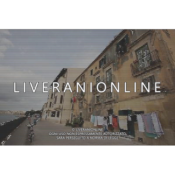 (131008) -- SYRACUSE, Oct. 8, 2013 () -- A woman does laundry outside her house along the seaside in Syracuse, Italy, Oct. 7, 2013. Ancient Syracuse includes the nucleus of the city\'s foundation as Ortygia by Greeks from Corinth in the 8th century BC. The site of the city, which Cicero described as \'the greatest Greek city and the most beautiful of all\', retains vestiges such as the Temple of Athena (5th century BC, later transformed to serve as a cathedral), a Greek theatre, a Roman amphitheatre, a fort and more. Many remains bear witness to the troubled history of Sicily, from the Byzantines to the Bourbons, interspersed with the Arab-Muslims, the Normans, Frederick II of the Hohenstaufen dynasty (1197--1250), the Aragons and the Kingdom of the Two Sicilies. Historic Syracuse offers a unique testimony to the development of Mediterranean civilization over three millennia. The UNESCO Commitee inscribed Syracuse as a world heritage site in 2005. (/Du Juanjuan) ©photoshot/AGENZIA ALDO LIVERANI SAS - ITALY ONLY - Il Centro storico della citta\' di Siracusa offre una testimonianza unica per lo sviluppo della civilta\' mediterranea oltre tre millenni inscritta dal Comitato UNESCO come sito del patrimonio mondiale nel 2005.