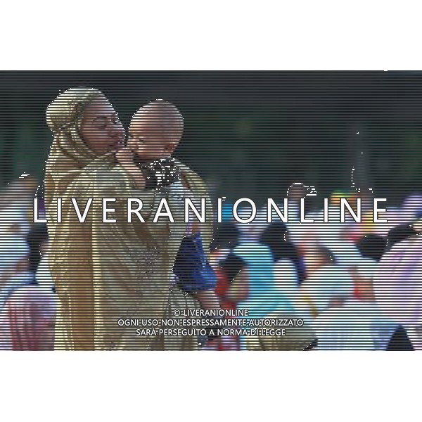 (131015) -- QUEZON CITY, Oct. 15, 2013 () -- A Muslim mother carries her son during the Muslim festival of Eid Al-Adha in Quezon City, the Philippines, Oct. 15, 2013. Muslims across the world celebrate the festival of Eid al-Adha, or the Festival of Sacrifice, in commemoration of Prophet Abraham\'s readiness to sacrifice his son to show obedience to God. (/Rouelle Umali) ©photoshot/AGENZIA ALDO LIVERANI SAS - ITALY ONLY - I musulmani di tutto il mondo festeggiano con la macellazione di animali, il primo giorno di Eid al-Adha, o Festa del Sacrificio, il 16 ottobre 2013.