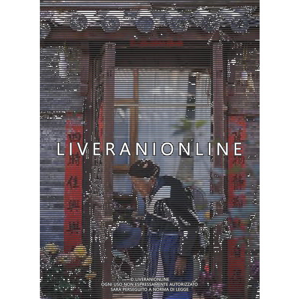 (131112) -- LIJIANG, Nov. 12, 2013 () -- An old woman of Naxi ethnic group stands in front of her house in the old town of Lijiang, southwest China\'s Yunnan Province, Nov. 5, 2013. (/Shen Hong) (mp) ©photoshot/AGENZIA ALDO LIVERANI SAS - ITALY ONLY - La popolazione e le abitazioni della citta\' vecchia di Lijiang, Cina sud-occidentale dello Yunnan Provincia , 6 novembre 2013.