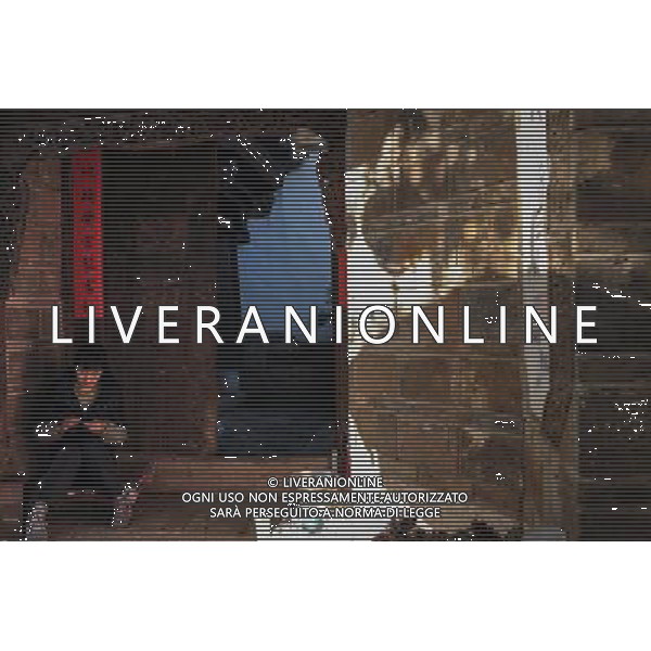 (131112) -- LIJIANG, Nov. 12, 2013 () -- A resident knits a sweater by the door of her house in the old town of Lijiang, southwest China\'s Yunnan Province, Nov. 7, 2013. (/Shen Hong) (mp) ©photoshot/AGENZIA ALDO LIVERANI SAS - ITALY ONLY - La popolazione e le abitazioni della citta\' vecchia di Lijiang, Cina sud-occidentale dello Yunnan Provincia , 6 novembre 2013.