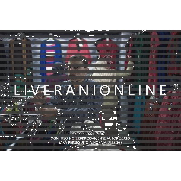 (131203) -- CAIRO, Dec. 3, 2013 () -- Salesclerk Ali arranges clothes in a cloth shop on Talaat Harb Street, near Tahrir Square, downtown Cairo, Egypt, on Dec. 2, 2013. Ali has been working for the 21-year-old cloth shop near the iconic Tahrir Square since 6 years ago and he has witnessed the business turbulence during domestic political changes. He admits that the shop owner Mohamed currently has to pay employees\' salary from his own pocket and business is greatly affected since 2011. As Ali said, the shop had to be closed at 3p.m. on Dec.1 which used to be the gold time for shopping for the reason that security forces fired teargas to disperse student supporters of ousted Islamist president Mohamed Morsi on the nearby Tahrir Square, which has been a storm center for Pro-Morsi protesters and their opponents. (/Pan Chaoyue) ©PHOTOSHOT/AGENZIA ALDO LIVERANI SAS - ITALY ONLY - EDITORIAL USE ONLY - Un negozio di stoffa e abbigliamento sulla Talaat Harb Street, nei pressi di piazza Tahrir, centro del Cairo, in Egitto, 2 dicembre 2013.