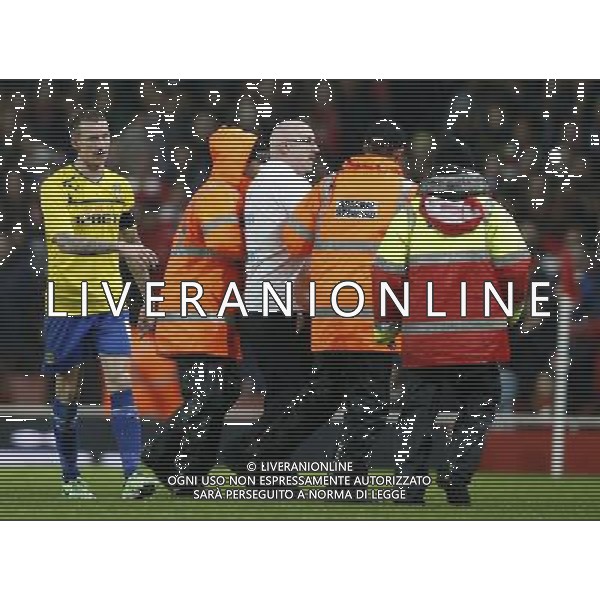 (140125) -- LONDON, Jan. 25, 2014 () -- A fan who invaded the pitch wearing a T-shirt written \'KEEP COVENTRY IN COVENTRY\' is taken off the pitch during FA Cup Fourth Round match between Arsenal and Coventry City at Emirates Stadium in London, Britain on Jan. 24, 2014. Coventry City lost 0-4 . (/Wang Lili) FOR EDITORIAL USE ONLY. NOT FOR SALE FOR MARKETING OR ADVERTISING CAMPAIGNS. NO USE WITH UNAUTHORIZED AUDIO, VIDEO, DATA, FIXTURE LISTS, CLUBLEAGUE LOGOS OR LIVE SERVICES. ONLINE IN-MATCH USE LIMITED TO 45 IMAGES, NO VIDEO EMULATION. NO USE IN BETTING, GAMES OR SINGLE CLUBLEAGUEPLAYER PUBLICATIONS. AG ALDO LIVERANI SAS ONLY ITALY