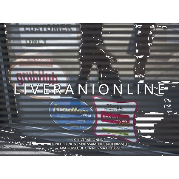 Stickers for Seamless and GrubHub internet food delivery services are seen on the window of a restaurant in Greenwich Village in New York on Tuesday, May 21, 2013. GrubHub, which merged with Seamless last year, debuted its initial public offering today on the New York Stock Exchange offering 7.4 million shares at $26 per share. The stock soon surged to $38 per share valuing the company at almost $200 million. ©photoshot/AGENZIA ALDO LIVERANI SAS - ITALY ONLY - EDITORIAL USE ONLY