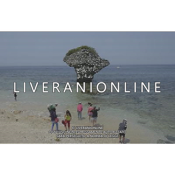 (140422) -- PINGTUNG, April 22, 2014 () -- Tourists frolic beside vase rock, a landmark in Liouciou Township in Pingtung County, southeast China\'s Taiwan, April 21, 2014. Liouciou township, which locates 8-9 nautical miles away from the Taiwan Island, has an area of 6.8 square meters. (/Huang Xiaoyong) (lfj) ©photoshot/AGENZIA ALDO LIVERANI SAS - ITALY ONLY - Vedute della citta\' portuale di Liouciou, a sud est della Cina a 8-9 miglia nautiche dall\'isola di Taiwan, ha una superficie di 6,8 metri quadrati 22 aprile 2014